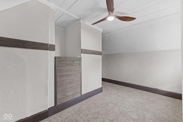 interior space featuring carpet floors, baseboards, vaulted ceiling, and a ceiling fan