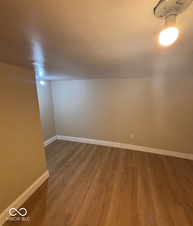 spare room featuring baseboards and wood finished floors