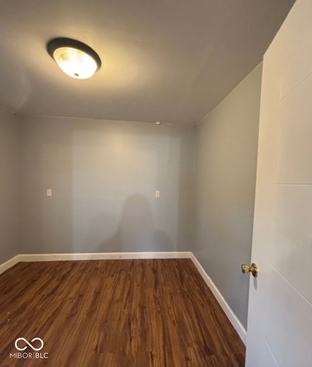 empty room with dark wood finished floors and baseboards