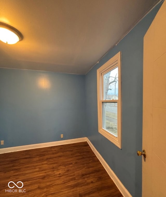 spare room with dark wood-style floors and baseboards