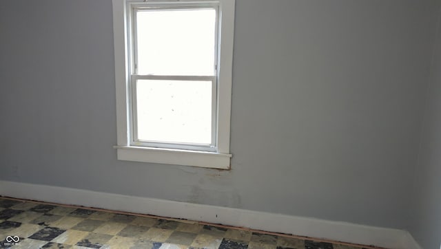 empty room featuring baseboards and tile patterned floors