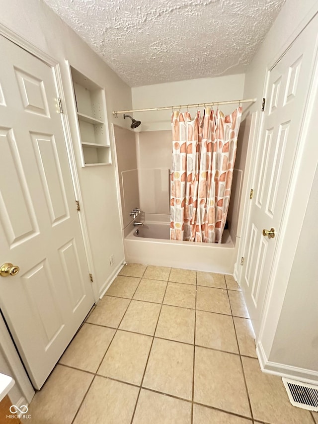 bathroom featuring a textured ceiling, shower / tub combo, visible vents, and tile patterned floors