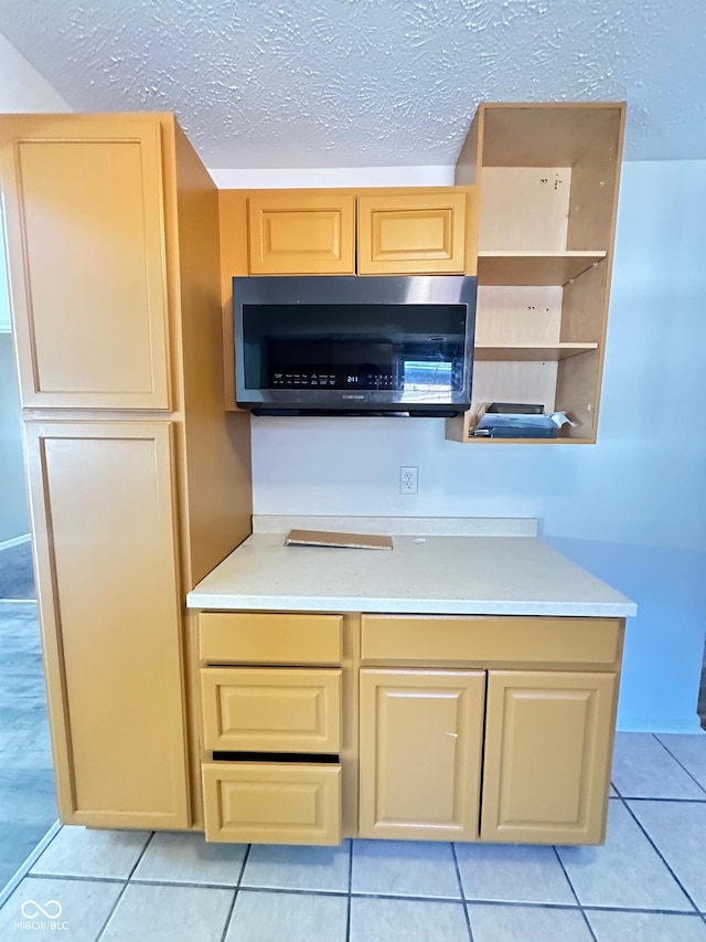 kitchen with open shelves, light tile patterned floors, stainless steel microwave, and light countertops