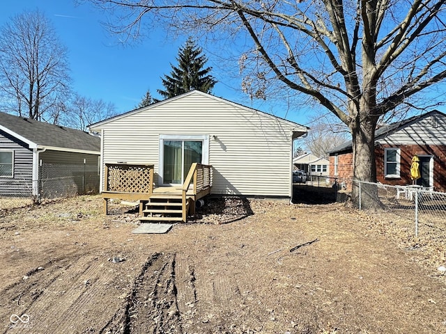 back of house featuring fence and a wooden deck