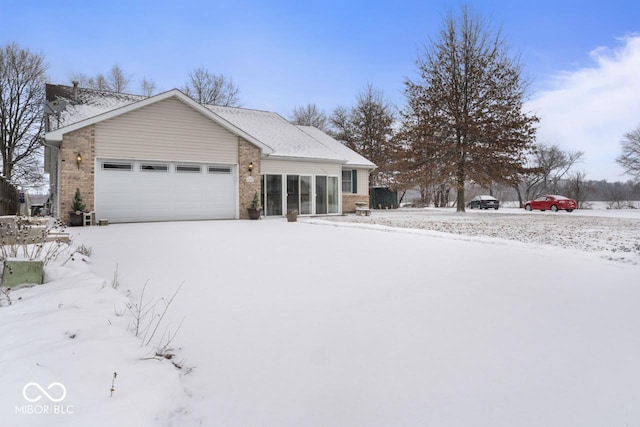 view of front of home featuring brick siding and a garage