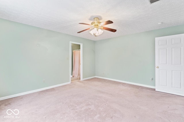 empty room featuring ceiling fan, light colored carpet, baseboards, and a textured ceiling