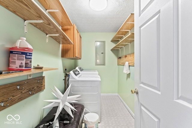 clothes washing area featuring washer and clothes dryer, electric panel, tile patterned floors, cabinet space, and a textured ceiling