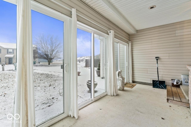 unfurnished sunroom featuring beamed ceiling