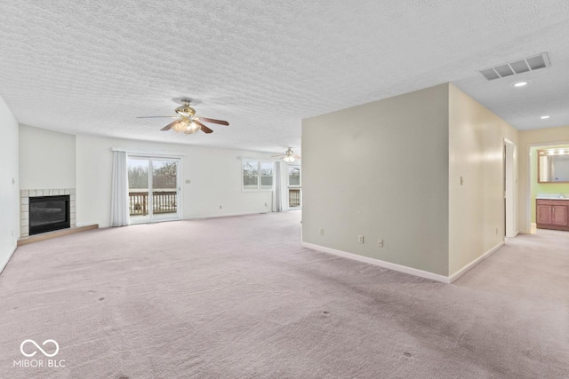 unfurnished living room featuring visible vents, light carpet, and a glass covered fireplace