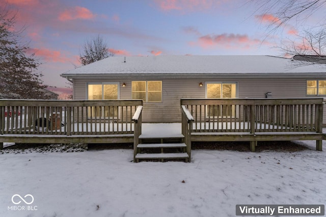 snow covered back of property featuring a deck