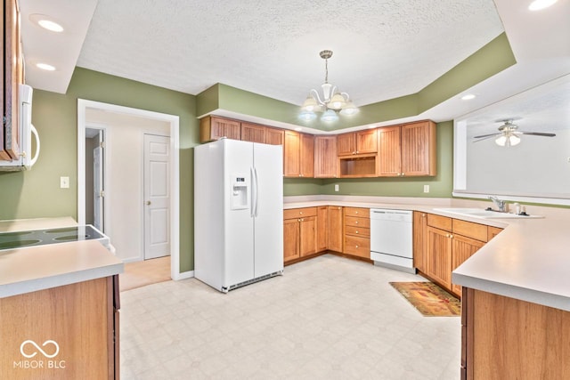 kitchen featuring a sink, white appliances, light floors, and a textured ceiling