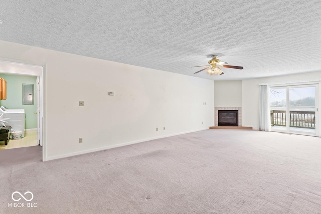 unfurnished living room with washer and dryer, carpet floors, electric panel, and a fireplace