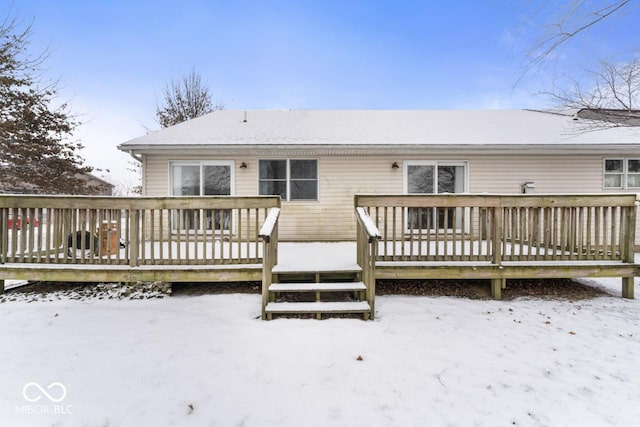 snow covered rear of property featuring a wooden deck