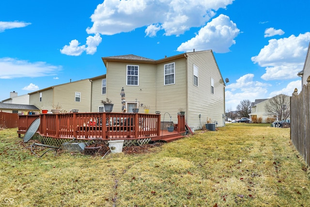 back of property with a deck, central AC, a yard, and fence