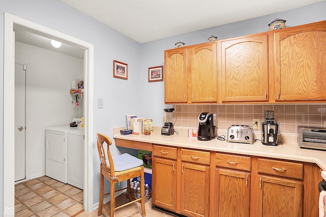 kitchen featuring washer and clothes dryer, a textured ceiling, tasteful backsplash, and light countertops