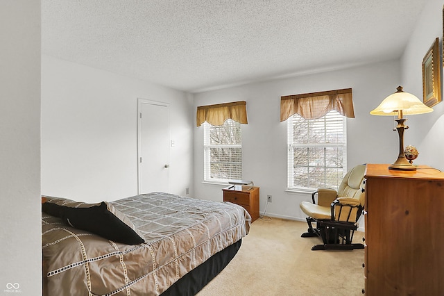 bedroom featuring carpet flooring, baseboards, and a textured ceiling