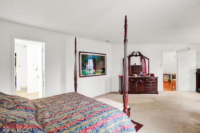 bedroom featuring light carpet and ensuite bath