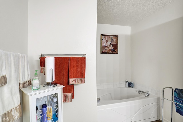 bathroom featuring a textured ceiling and a garden tub