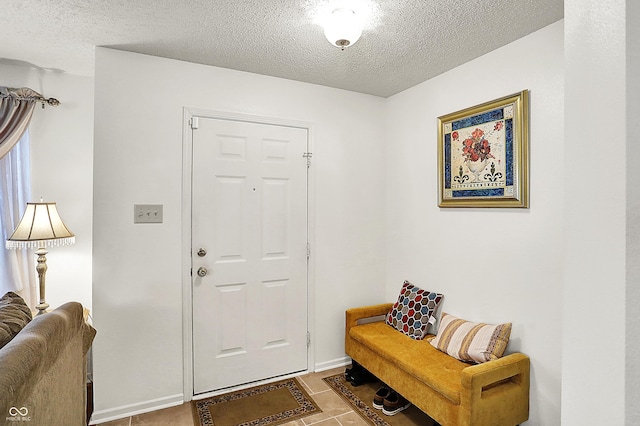 tiled entryway featuring a textured ceiling