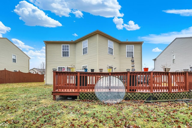 rear view of house featuring a lawn and a wooden deck