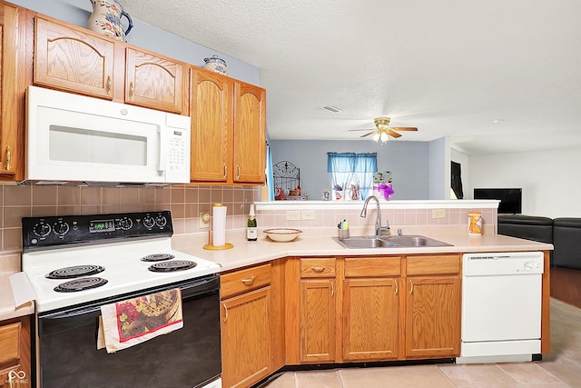 kitchen with visible vents, a sink, open floor plan, white appliances, and a peninsula