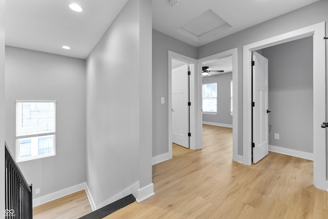 corridor featuring baseboards, recessed lighting, attic access, and light wood-style floors