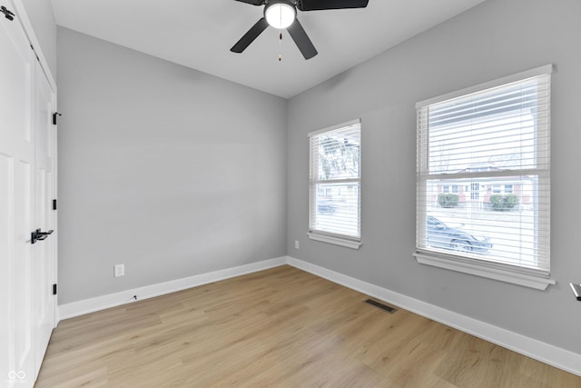 unfurnished room with visible vents, ceiling fan, light wood-style flooring, and baseboards