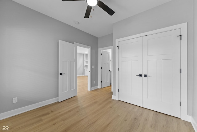 unfurnished bedroom featuring light wood-type flooring, a ceiling fan, baseboards, and a closet