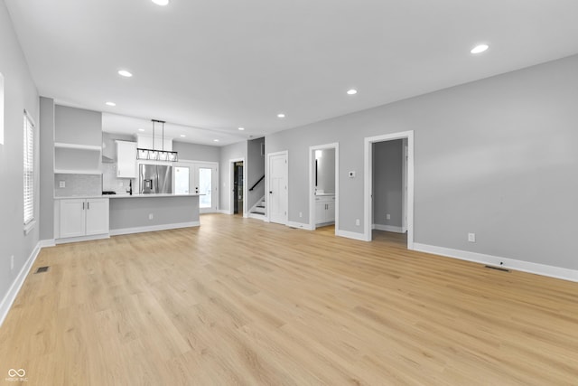 unfurnished living room featuring baseboards, recessed lighting, visible vents, and light wood-style floors