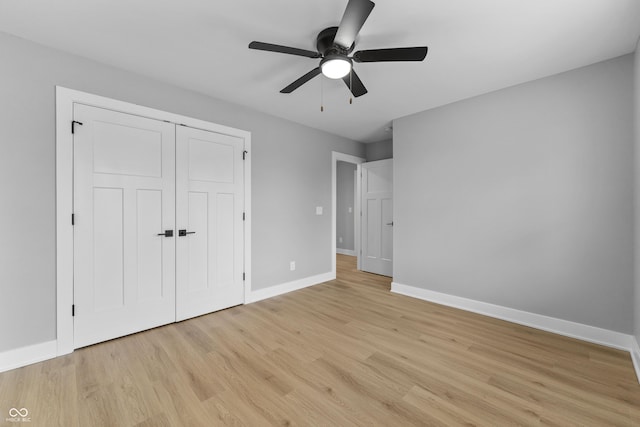 unfurnished bedroom featuring light wood finished floors, a closet, a ceiling fan, and baseboards