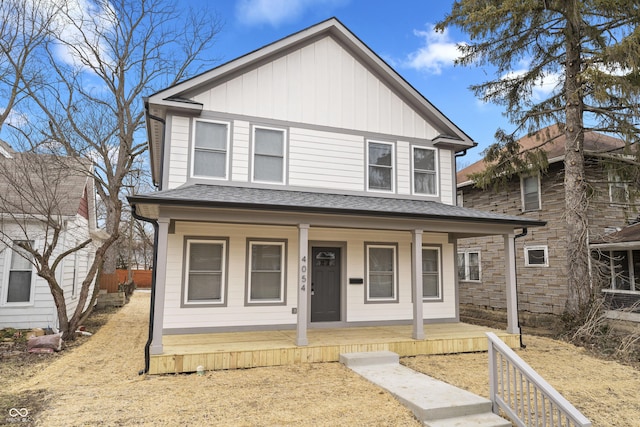 view of front of house with covered porch, board and batten siding, and roof with shingles