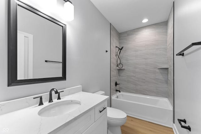 full bath with recessed lighting, toilet, vanity, wood finished floors, and  shower combination