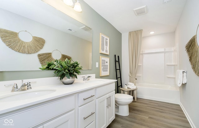 full bath featuring toilet, visible vents, a sink, and wood finished floors