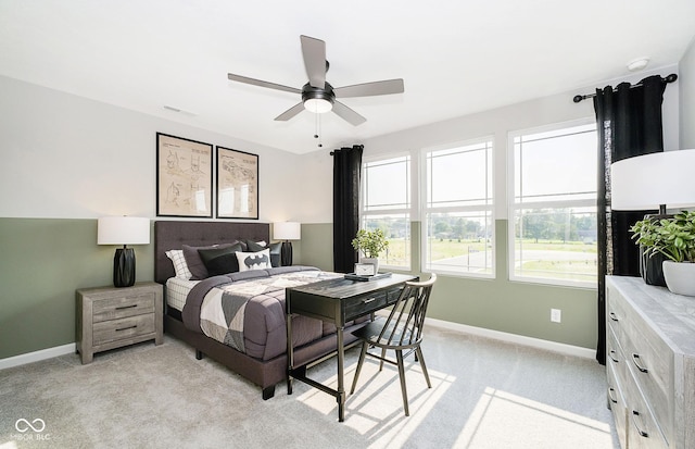 bedroom with light carpet, ceiling fan, visible vents, and baseboards