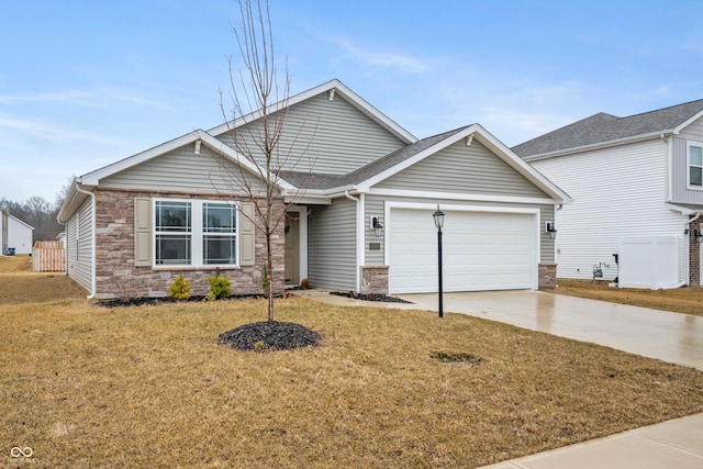 view of front of house featuring a garage, a front yard, stone siding, and concrete driveway