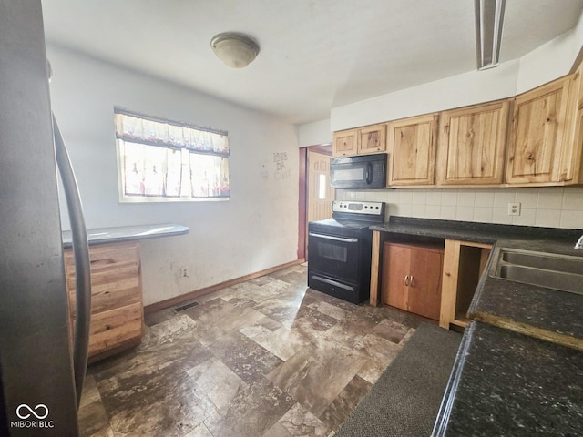 kitchen with a sink, baseboards, decorative backsplash, black appliances, and dark countertops