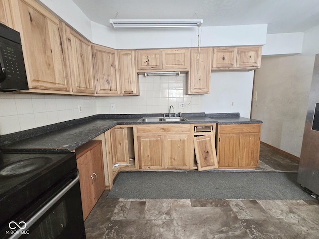 kitchen featuring dark countertops, a sink, backsplash, and black appliances