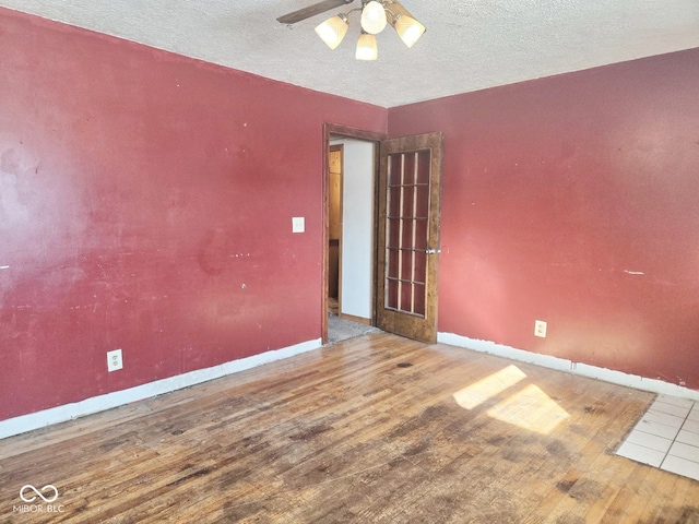 unfurnished room featuring ceiling fan, baseboards, and wood finished floors