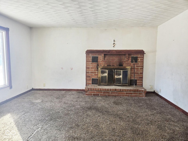 unfurnished living room featuring carpet, a fireplace, and baseboards