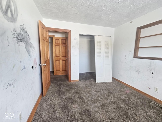 unfurnished bedroom with carpet floors, a closet, visible vents, a textured ceiling, and baseboards