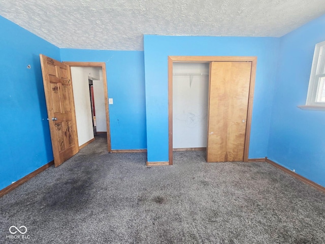 unfurnished bedroom with a textured ceiling, a closet, carpet flooring, and baseboards