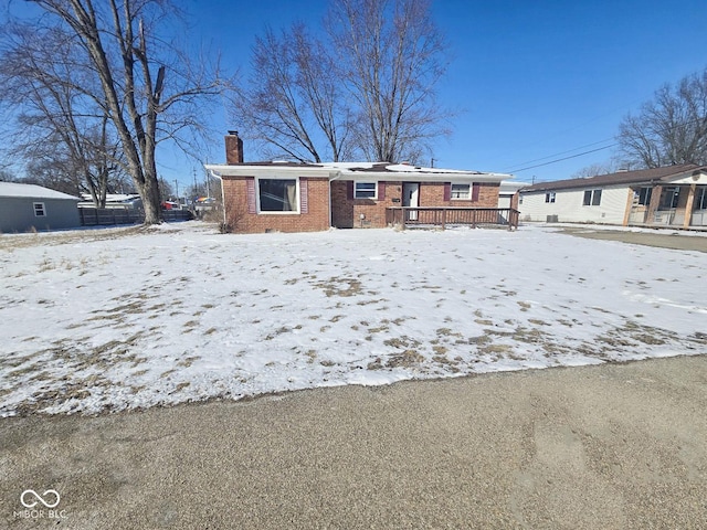 view of front of property with crawl space, brick siding, and a chimney