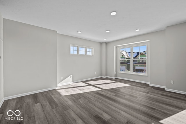 empty room featuring baseboards, wood finished floors, and recessed lighting