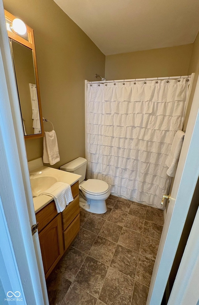 bathroom with vanity, curtained shower, and toilet