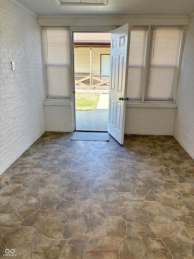 interior space with brick wall and stone flooring