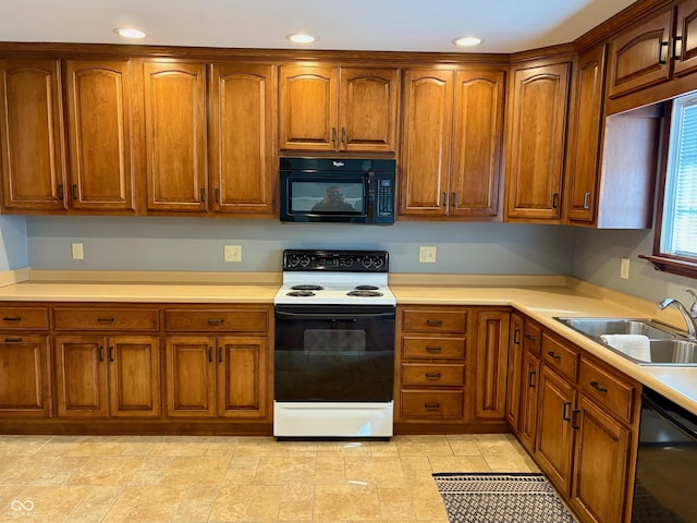 kitchen featuring black appliances, brown cabinetry, light countertops, and a sink