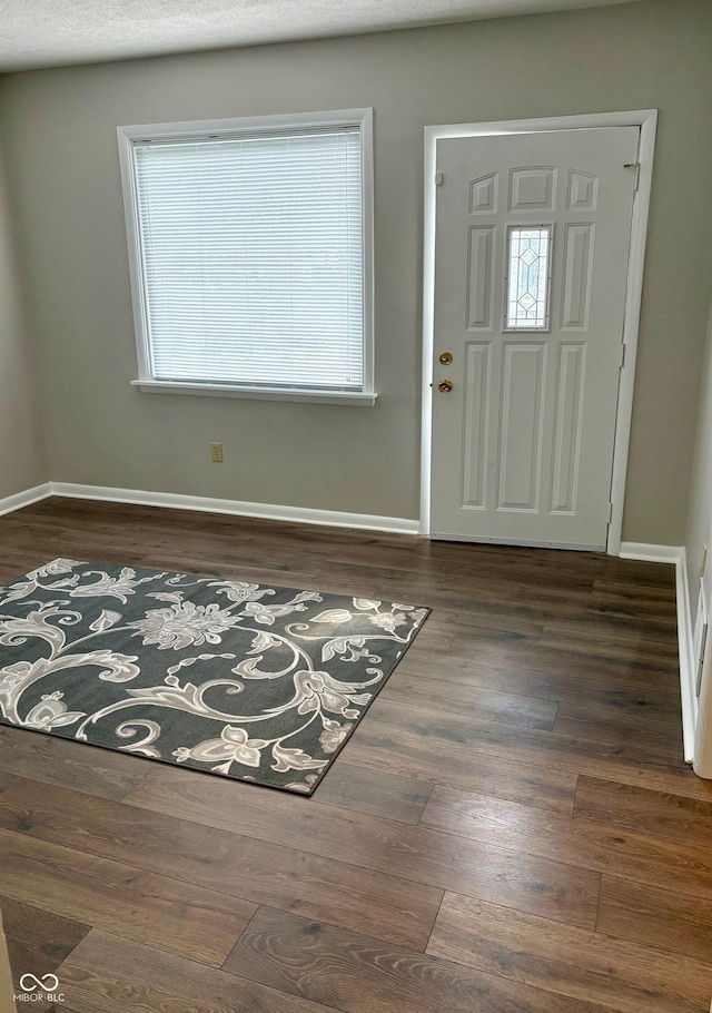 foyer featuring baseboards and wood finished floors