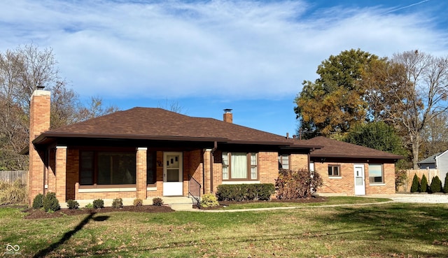 ranch-style home featuring a front yard, fence, brick siding, and a chimney