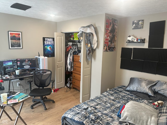 bedroom with a textured ceiling and light wood-type flooring