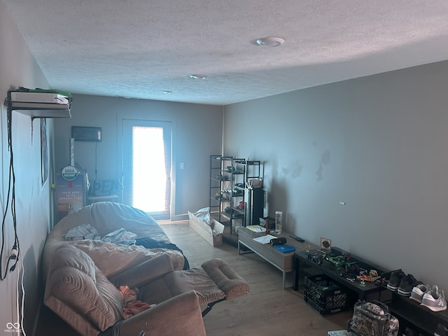 bedroom featuring wood finished floors and a textured ceiling